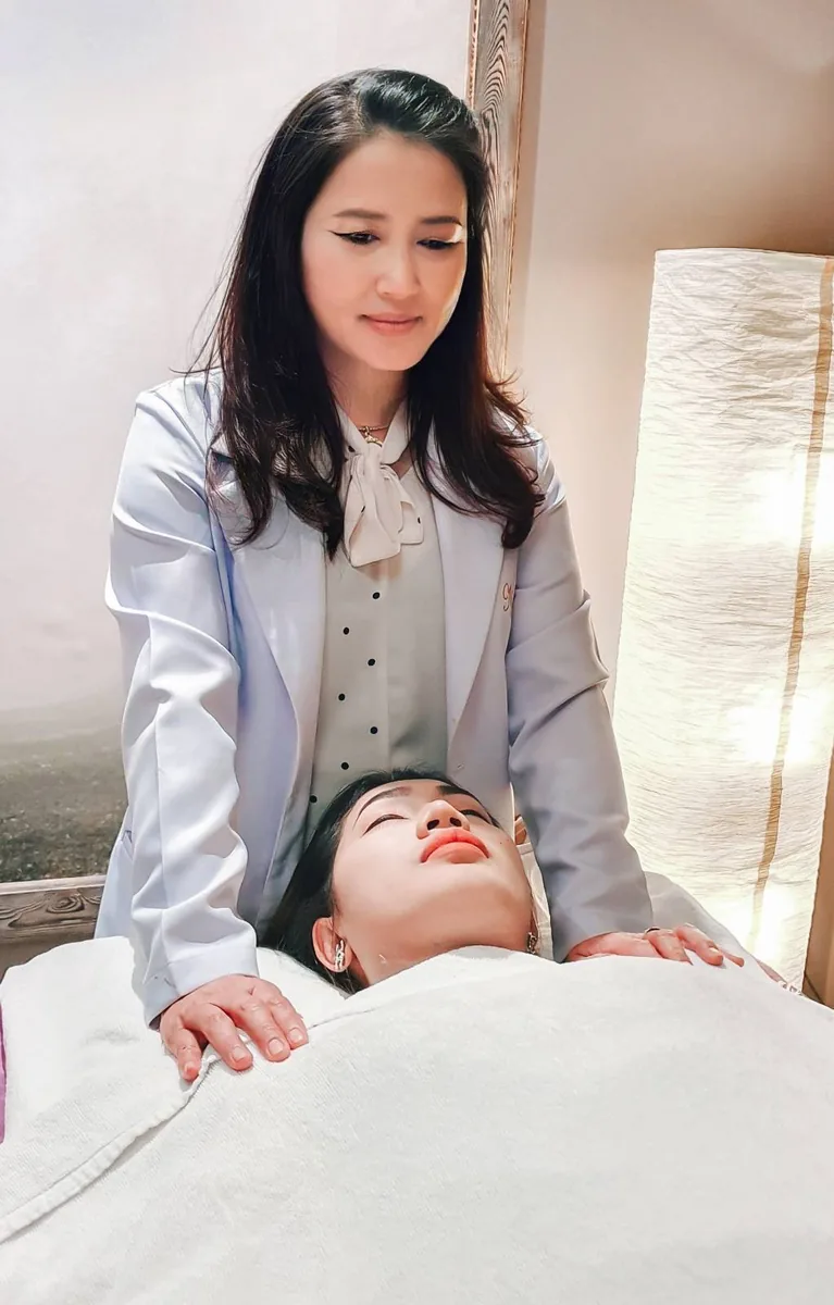 พนักงานยืนข้างเตียงเพื่อเตรียมลูกค้าก่อนนวดหน้า