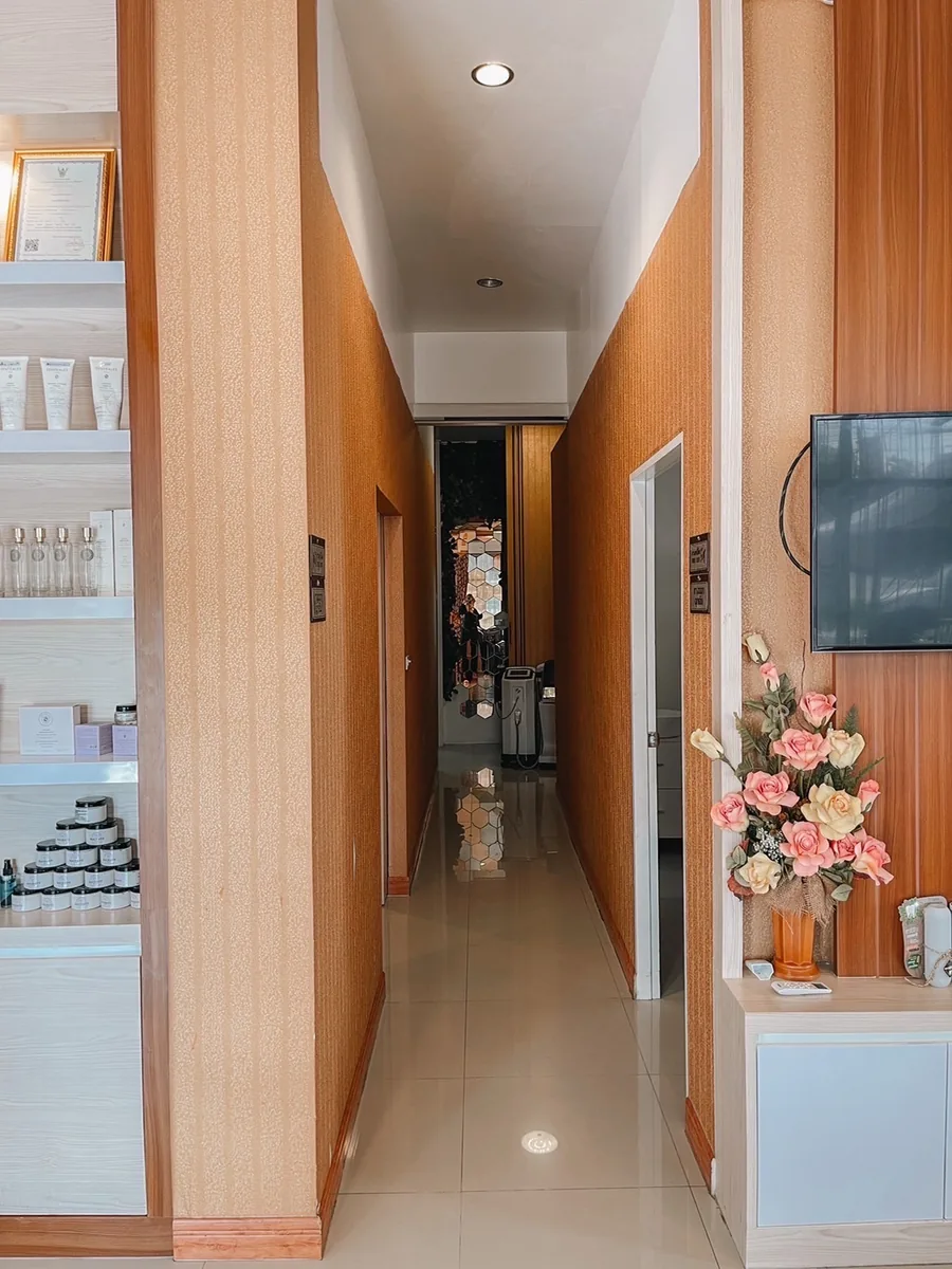 ทางเดินภายในร้านที่ปูพื้นไม้ มีกระจกและเคาน์เตอร์อยู่ปลายทาง