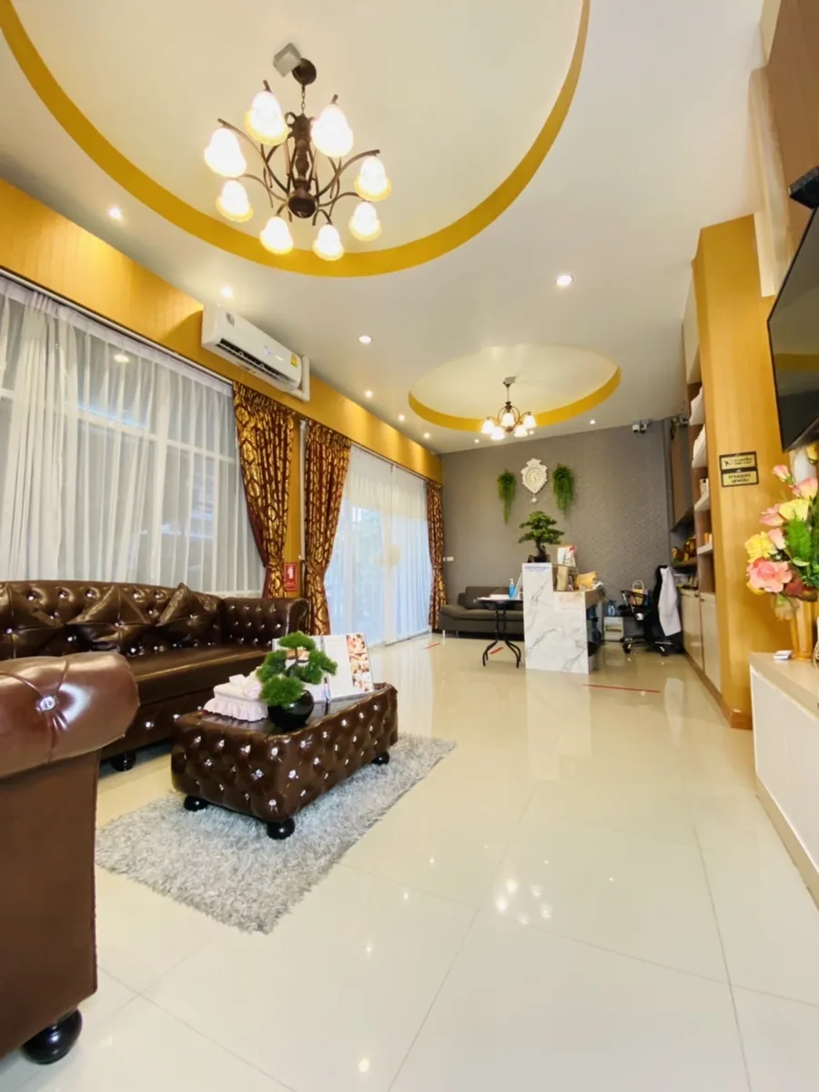 โถงรอของร้านที่มีโซฟาหนังและพรมปูพื้น ด้านหลังมีฉากกั้นไม้