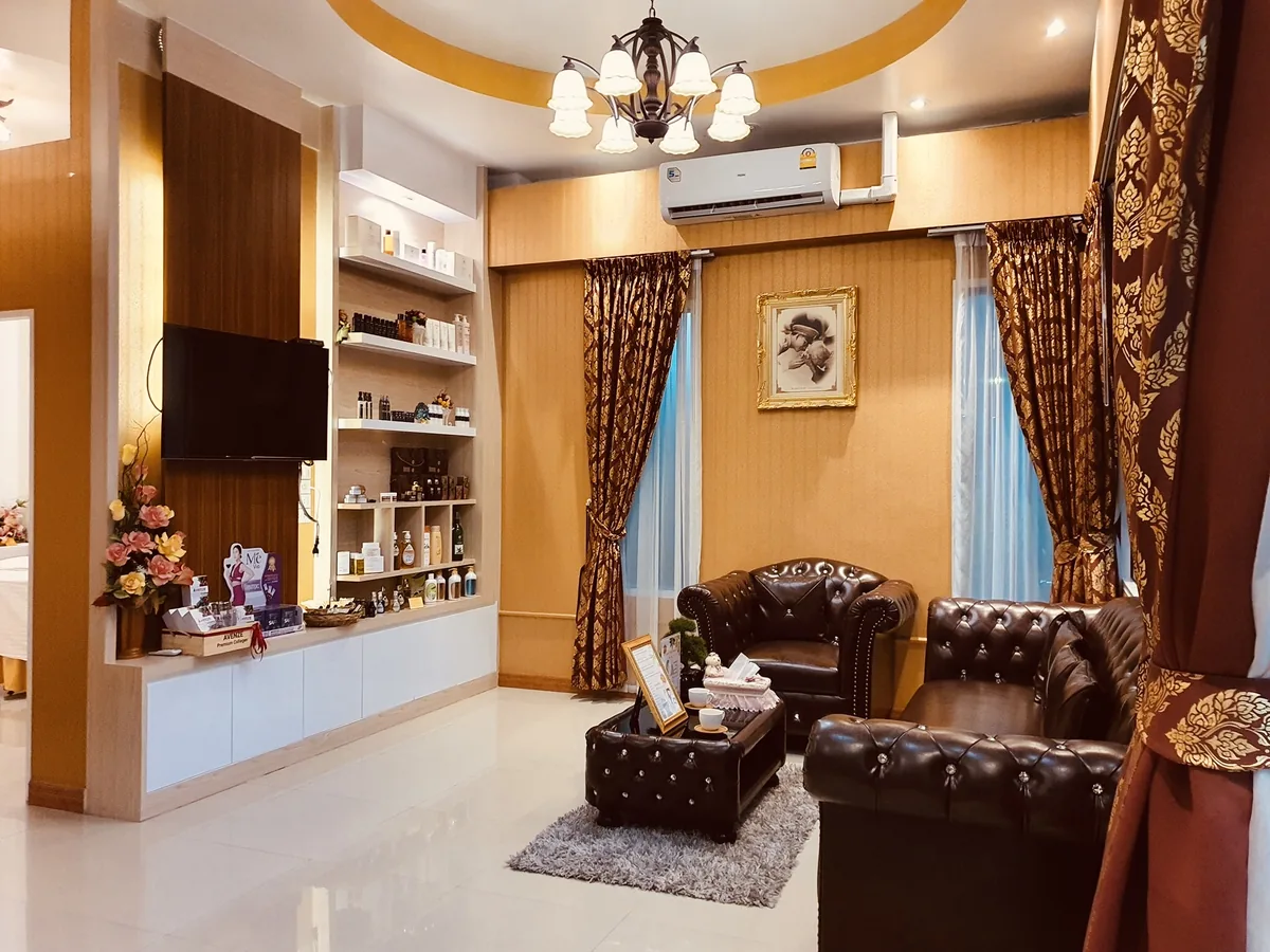 มุมนั่งเล่นที่มีโซฟา ชั้นวางของ และโคมไฟระย้าในโถงของร้าน
