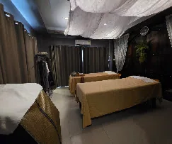 ห้องบริการหลายเตียงที่เพดานตกแต่งด้วยผ้าโปร่งสีขาว