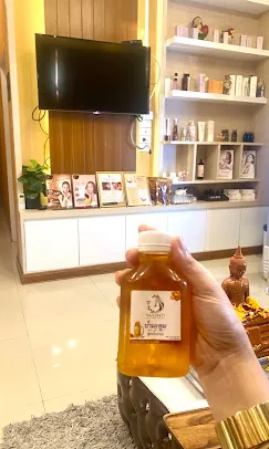 ขวดน้ำมะตูมแช่เย็นที่ถืออยู่หน้ามุมขายผลิตภัณฑ์ของร้าน