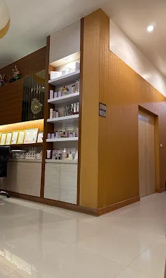 ชั้นวางผลิตภัณฑ์ของร้านบนผนังบุไม้ พร้อมตู้เก็บของด้านล่าง