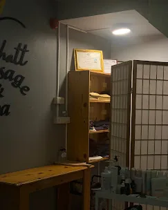 มุมด้านในร้านที่มีชั้นวางผ้าและของใช้ โต๊ะไม้ และรถเข็นอุปกรณ์